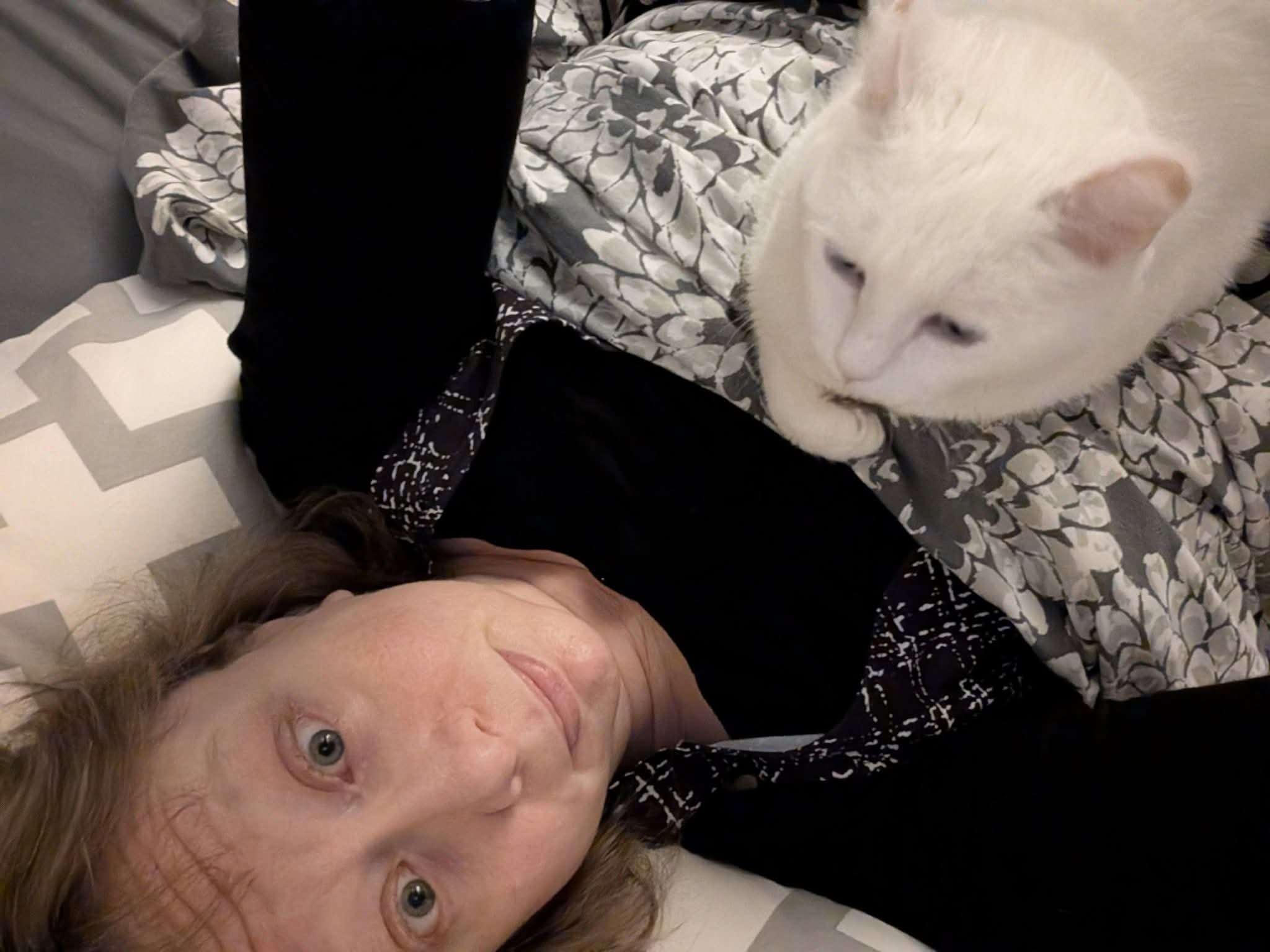 Meg wth Coco on her chest- a white cat who had her ears freeze off when she was a stray